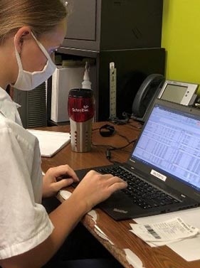 A student typing on a laptop computer.