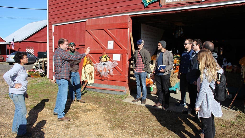 tudents standing in front of a barn on a farm.